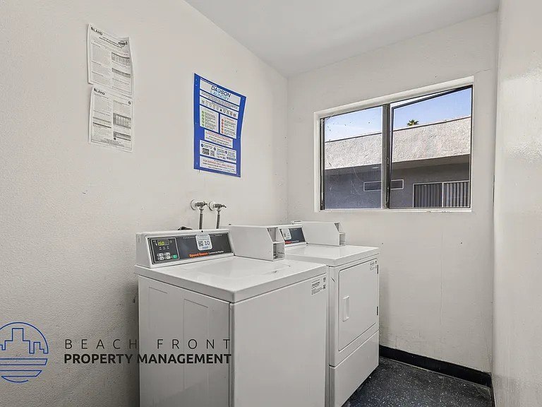 A white wall with a window and a sign that says Beach Front Property Management.